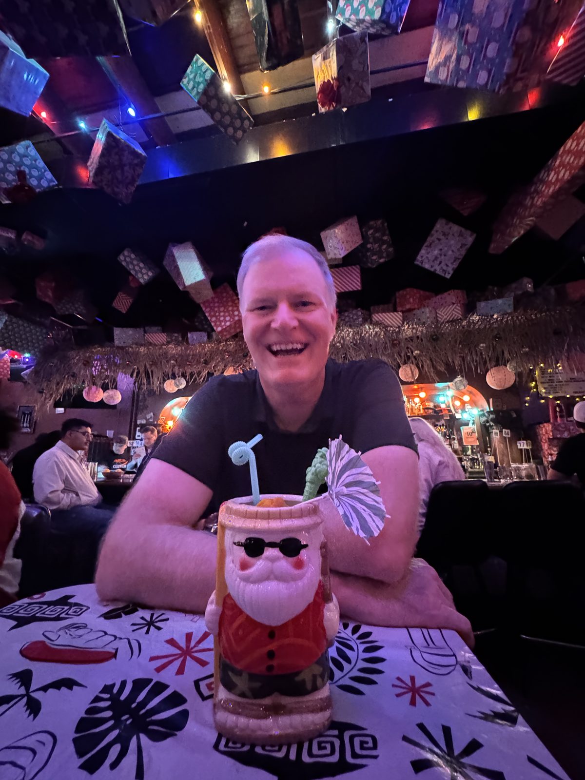 Todd laughing in a tiki bar decorated for the holidays
