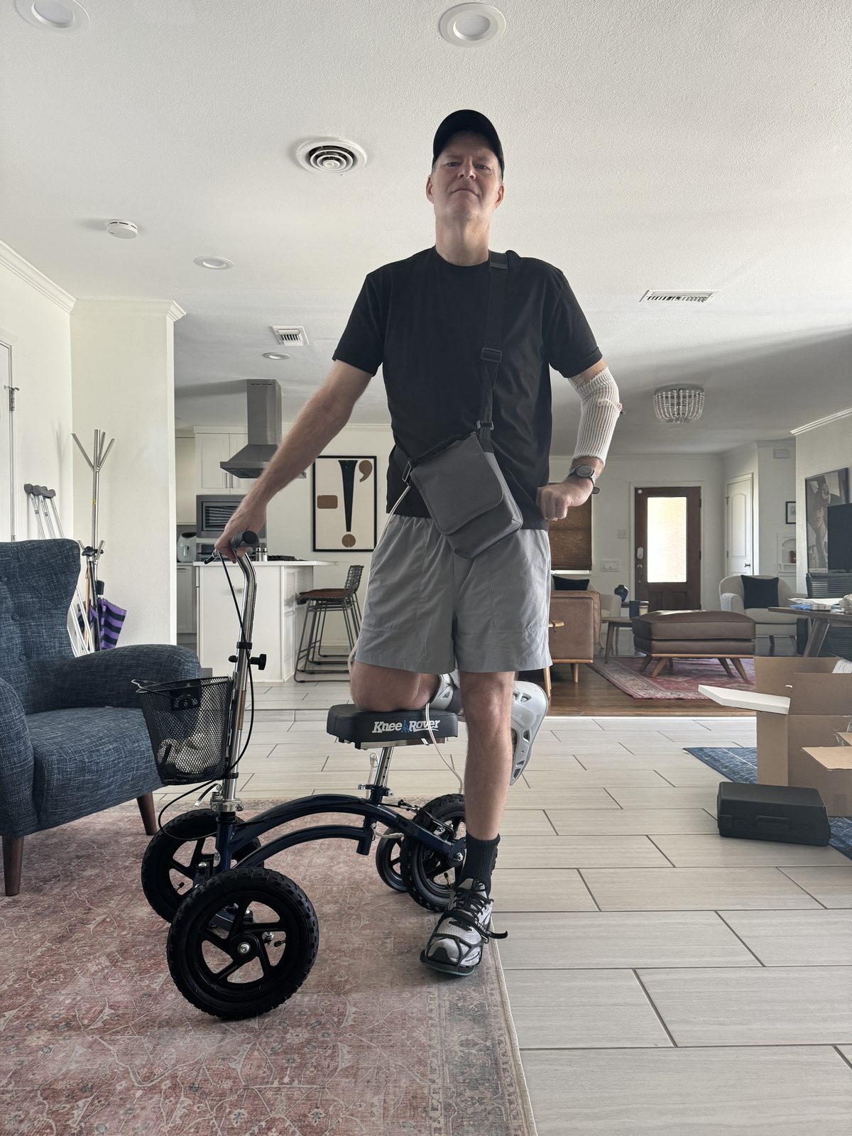 Todd posing with a knee scooter at home